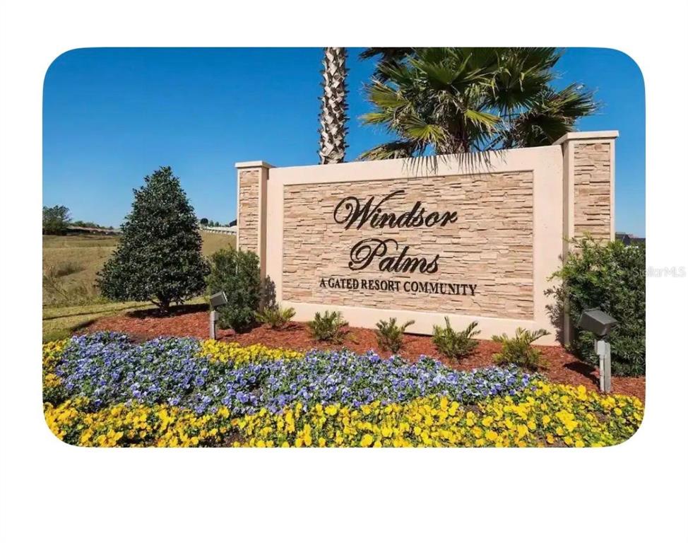 A stone monument sign for Windsor Palms resort community stands behind a bed of flowers — 8107 COCONUT PALM WAY UNIT 201, KISSIMMEE, FL