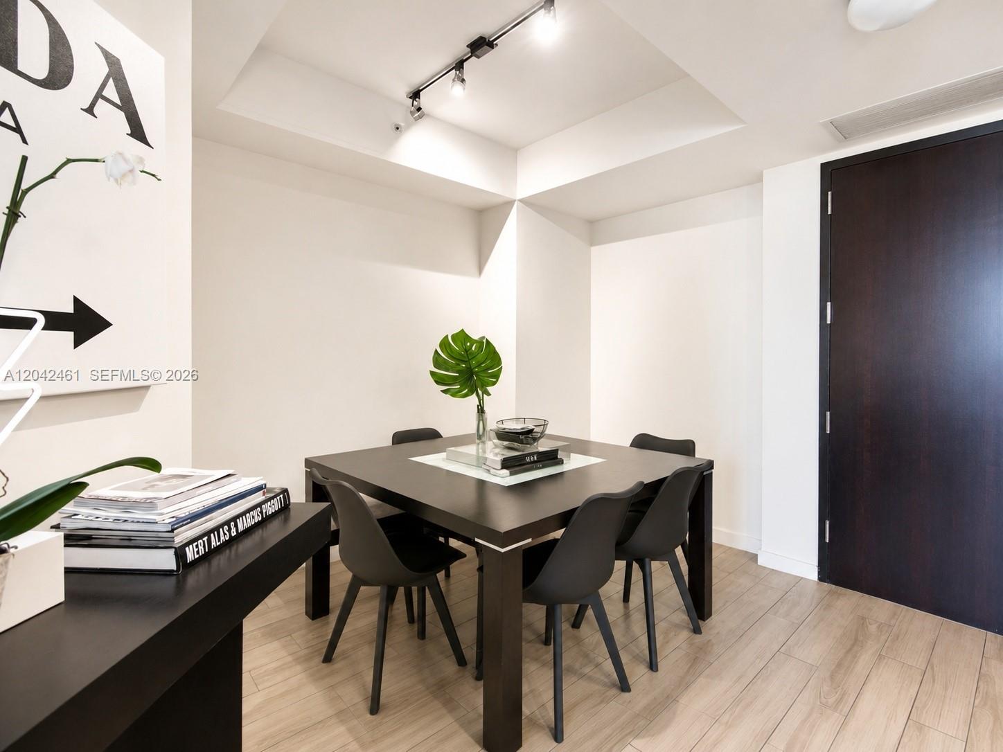 A dining area features a dark square table, four black chairs, and light wood flooring — 999 SW 1st Ave # 2211, Miami FL 33130, MIAMI, FL