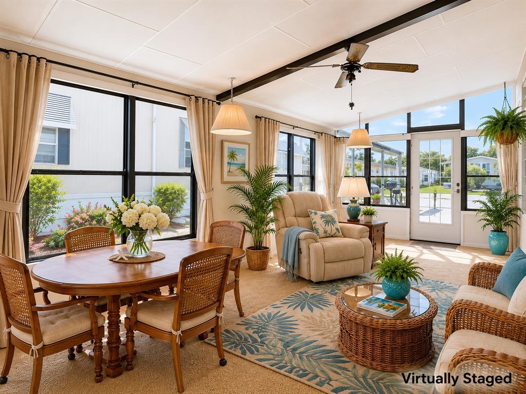 This sunroom features a dining area, a seating area, large windows, and a ceiling fan — 35801 BRISA DRIVE, ZEPHYRHILLS, FL
