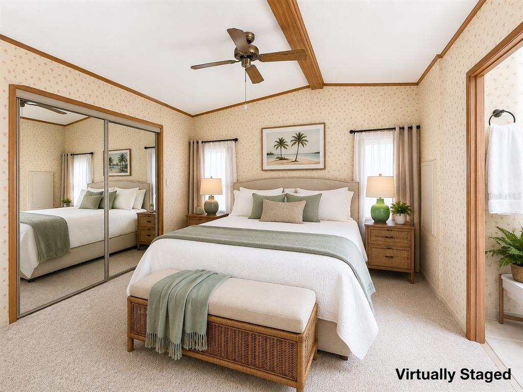A bedroom with floral wallpaper, a queen bed, a ceiling fan, and mirrored closet doors — 35801 BRISA DRIVE, ZEPHYRHILLS, FL