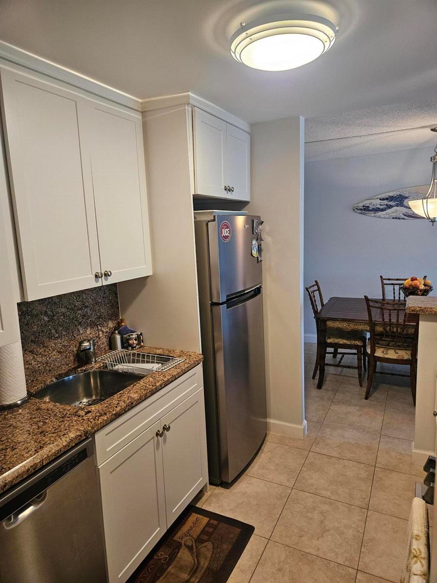 A kitchen with white cabinets, granite countertops, and a stainless steel refrigerator — 2121 N Ocean Boulevard N # 405e, Boca Raton FL 33431, BOCA RATON, FL