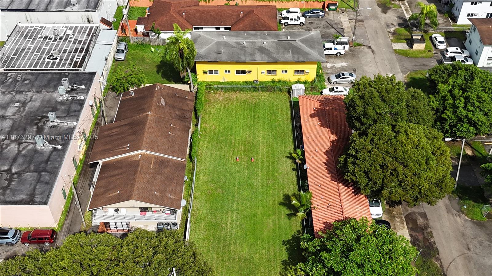 An aerial view shows a vacant grassy lot situated between two residential buildings — 1941 NW 19th Ave, Miami FL 33125, MIAMI, FL