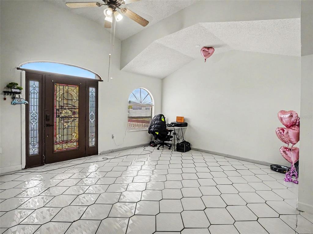 A bright room features white hexagonal floor tiles, a vaulted ceiling, and a decorative entryway — 151 TULPAN DRIVE, KISSIMMEE, FL
