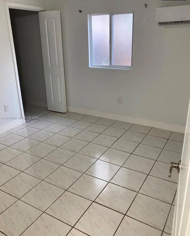 This room features light-colored floor tiles, white walls, a window, and a doorway — 141 W 26th St, Hialeah FL 33010, HIALEAH, FL