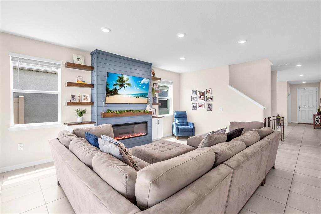 An open-concept living room and kitchen featuring a large sectional sofa and water views — 18015 FATTORIA TERRACE, LAKEWOOD RANCH, FL
