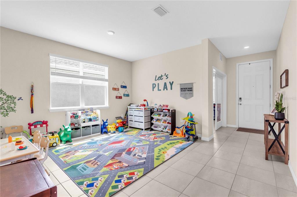 A modern kitchen features white cabinets, a marble-topped island with three chairs, and stainless appliances — 18015 FATTORIA TERRACE, LAKEWOOD RANCH, FL