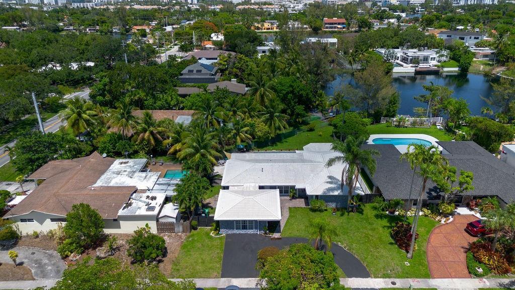 An aerial view of a suburban neighborhood featuring houses with pools and lush tropical landscaping — 19885 NE 22nd Avenue, Miami FL 33180, MIAMI, FL