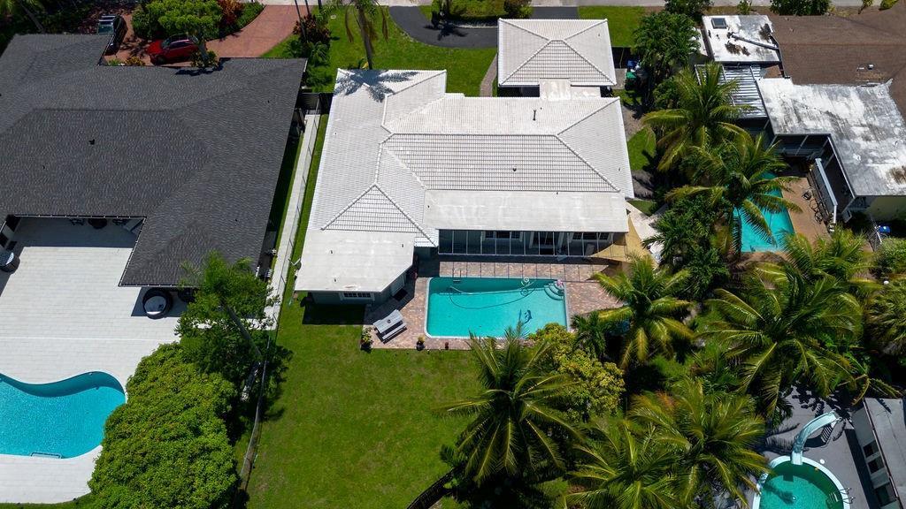 An aerial view shows a house with a white tile roof, swimming pool, and landscaping — 19885 NE 22nd Avenue, Miami FL 33180, MIAMI, FL
