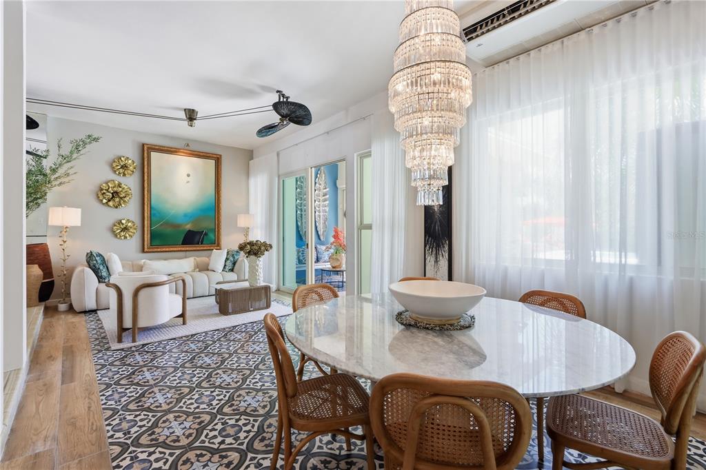 A dining area with a marble table and crystal chandelier opens into a living room — 46 AQUABELLA UNIT 46, HUMACAO, PR