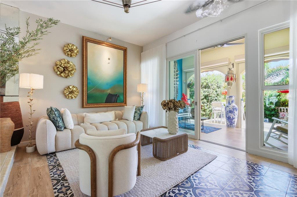 A living room features a cream sofa, a modern armchair, and sliding doors to a patio — 46 AQUABELLA UNIT 46, HUMACAO, PR