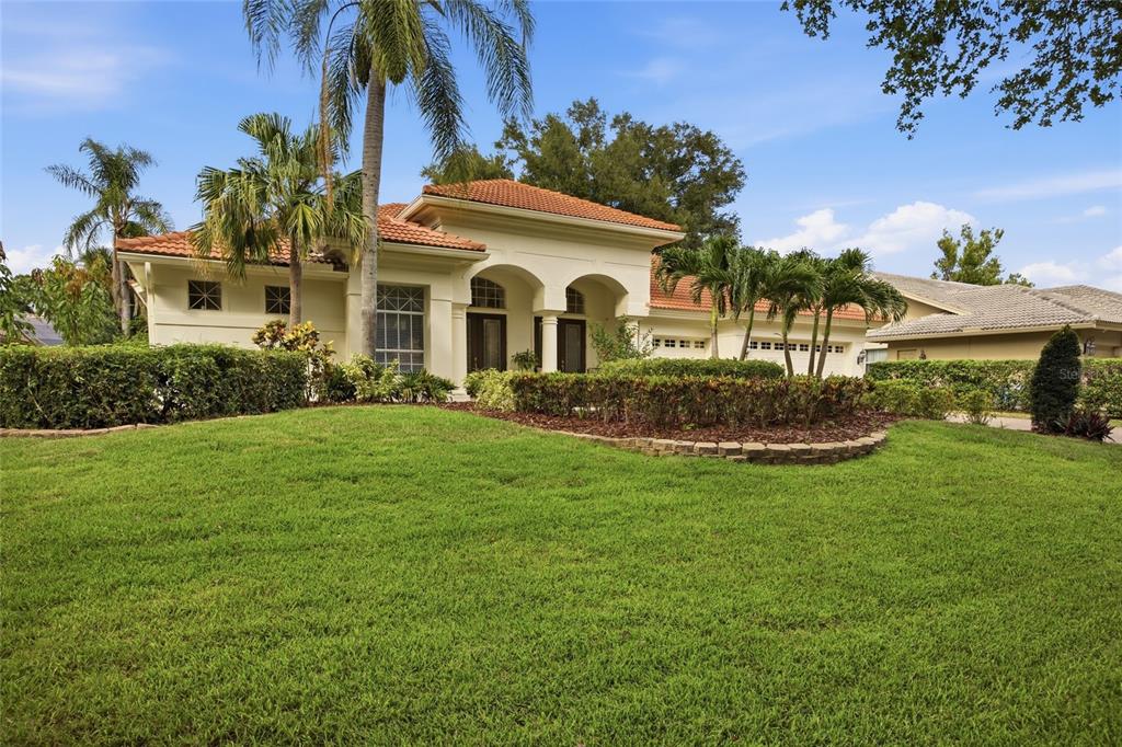 An aerial view shows a house with a tiled roof, solar panels, and a backyard pool — 3459 WOODRIDGE PARKWAY, PALM HARBOR, FL