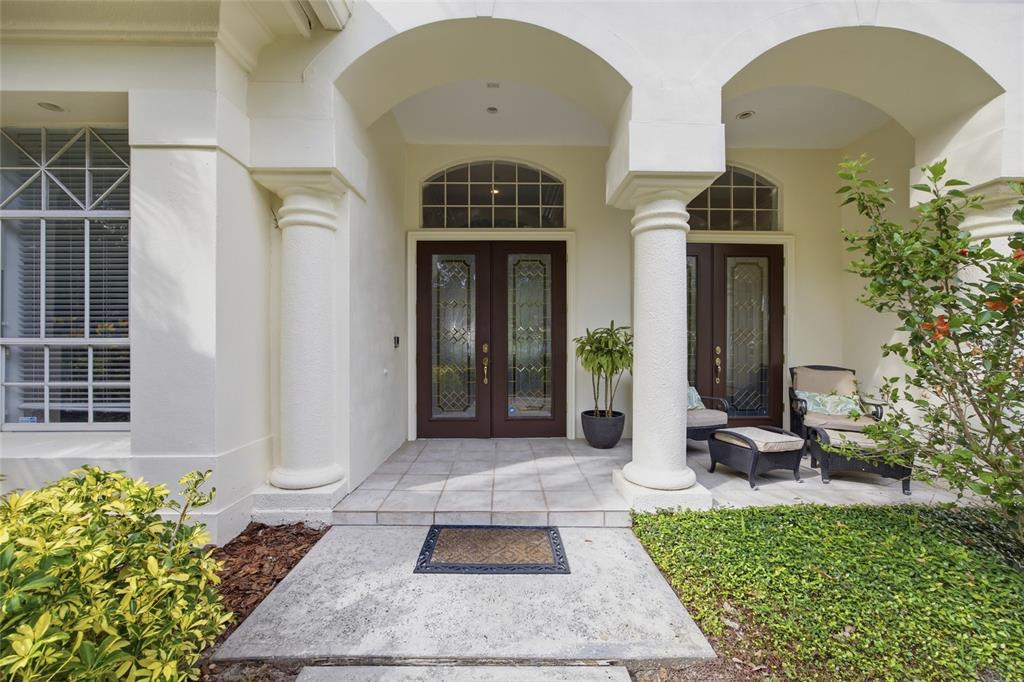 A single-story stucco house with a tile roof, arched entryway, and palm trees in front — 3459 WOODRIDGE PARKWAY, PALM HARBOR, FL