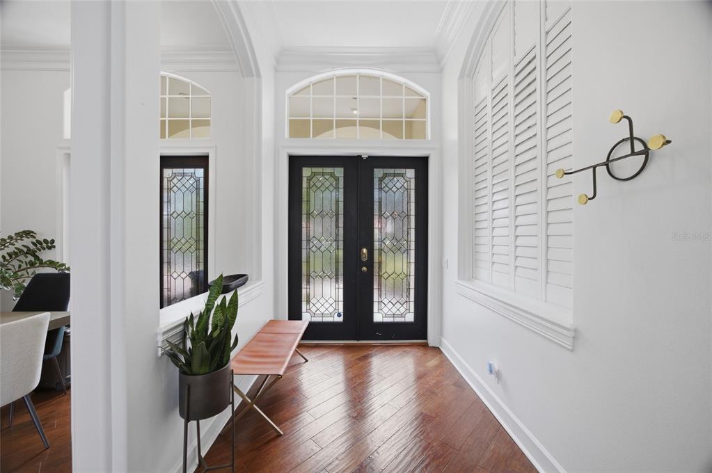 A single-story house with a terracotta tile roof, a three-car garage, and landscaped front yard — 3459 WOODRIDGE PARKWAY, PALM HARBOR, FL
