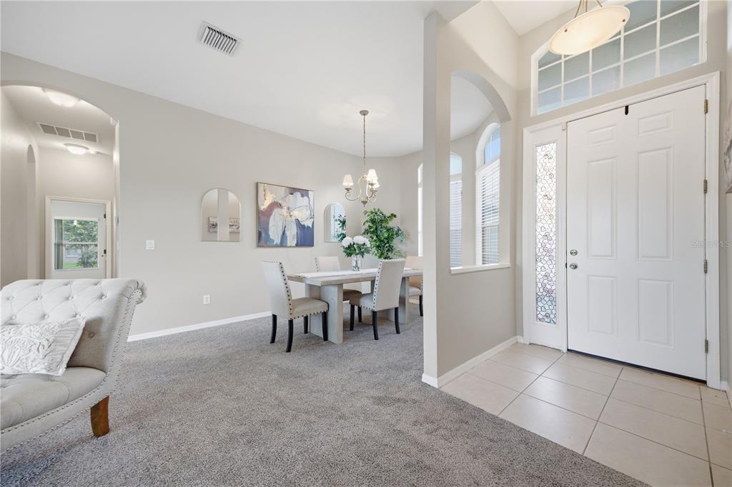 A dining area with a table and chairs sits adjacent to a tiled entryway — 7006 ORVICTI COURT, WESLEY CHAPEL, FL