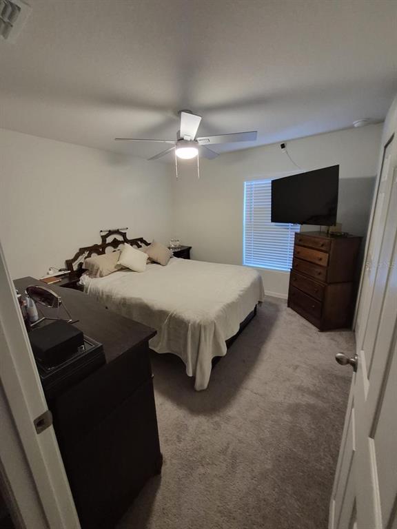 A bedroom features a bed with a dark headboard, a ceiling fan, and a dresser — 17103 SW 22ND TERRACE ROAD, OCALA, FL