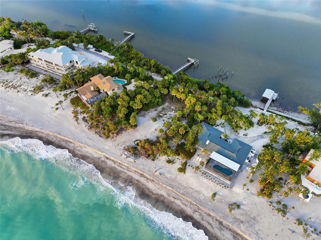 An aerial view shows several beachfront houses with private pools and docks along the coast — 765 N MANASOTA KEY ROAD, ENGLEWOOD, FL