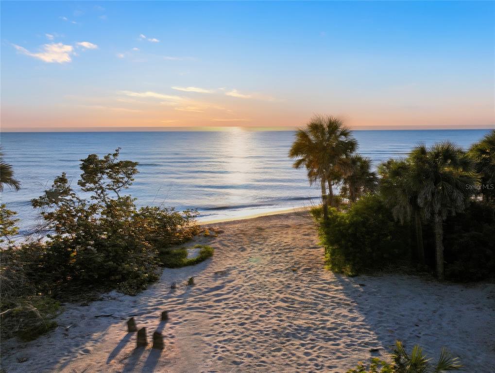 A sandy path leads through tropical vegetation toward the ocean at sunset — 765 N MANASOTA KEY ROAD, ENGLEWOOD, FL