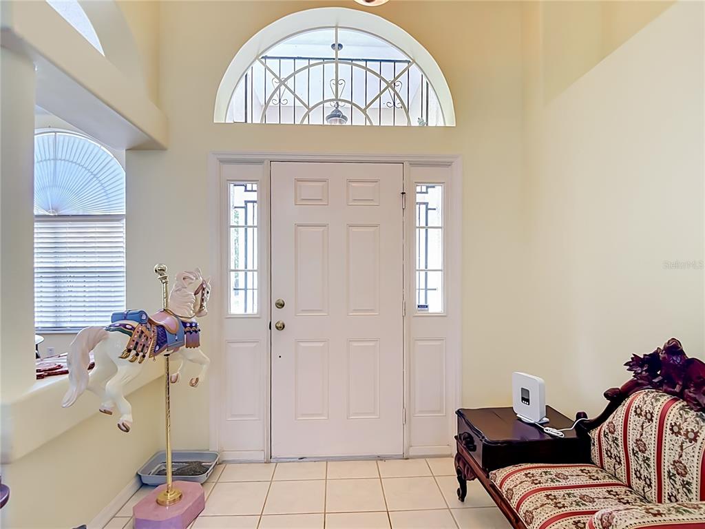 A single-story house with a paved driveway and two decorative wagon wheels in the yard — 8338 HANDCART ROAD, WESLEY CHAPEL, FL