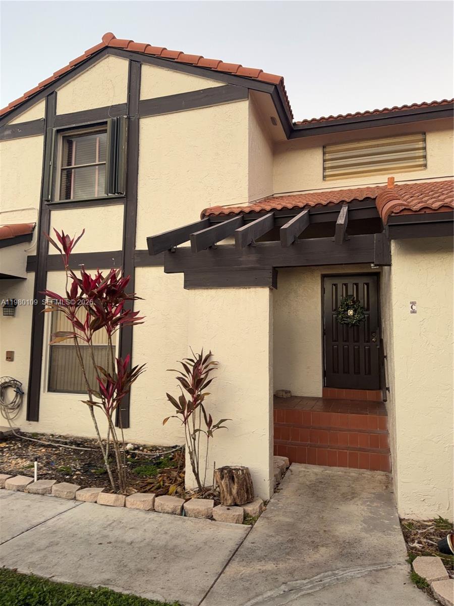 The exterior of a two-story stucco home features dark wood trim and a tiled roof — 15202 SW 46th Ln # 75, Miami FL 33185, MIAMI, FL
