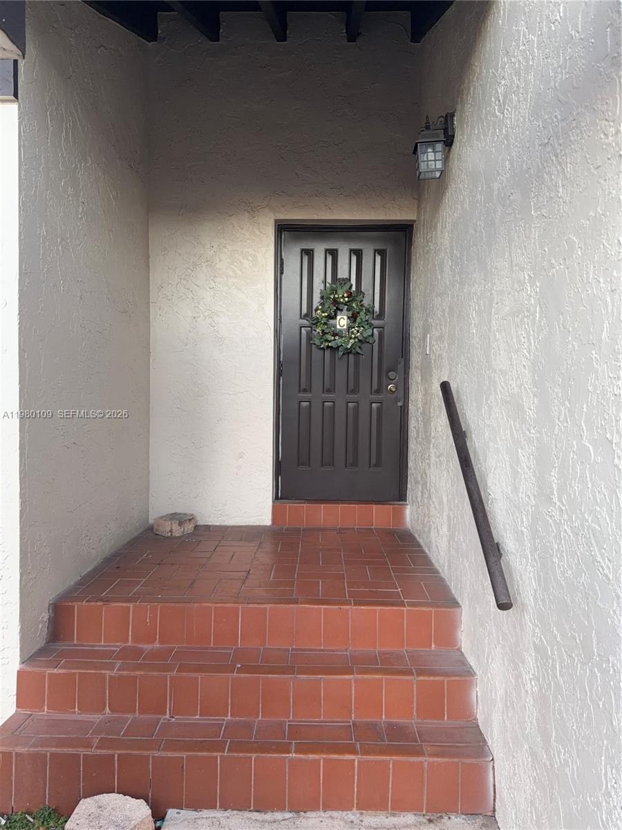 A dark brown front door with a wreath is accessed by three tiled steps — 15202 SW 46th Ln # 75, Miami FL 33185, MIAMI, FL