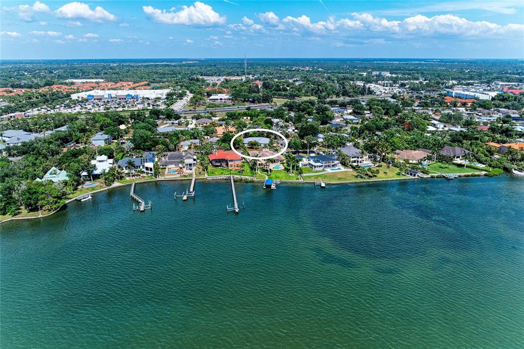 An aerial view shows a waterfront house circled in white along a residential coastline — 347 BAYSHORE DRIVE, OSPREY, FL