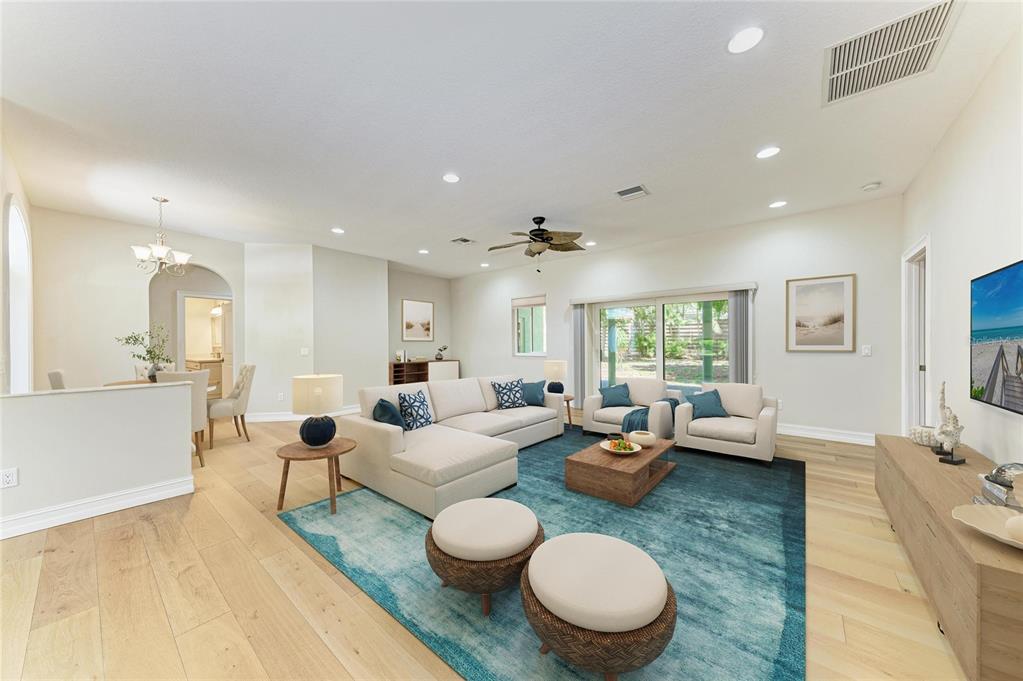 A living room features light wood floors, a large blue area rug, and a sectional sofa — 347 BAYSHORE DRIVE, OSPREY, FL