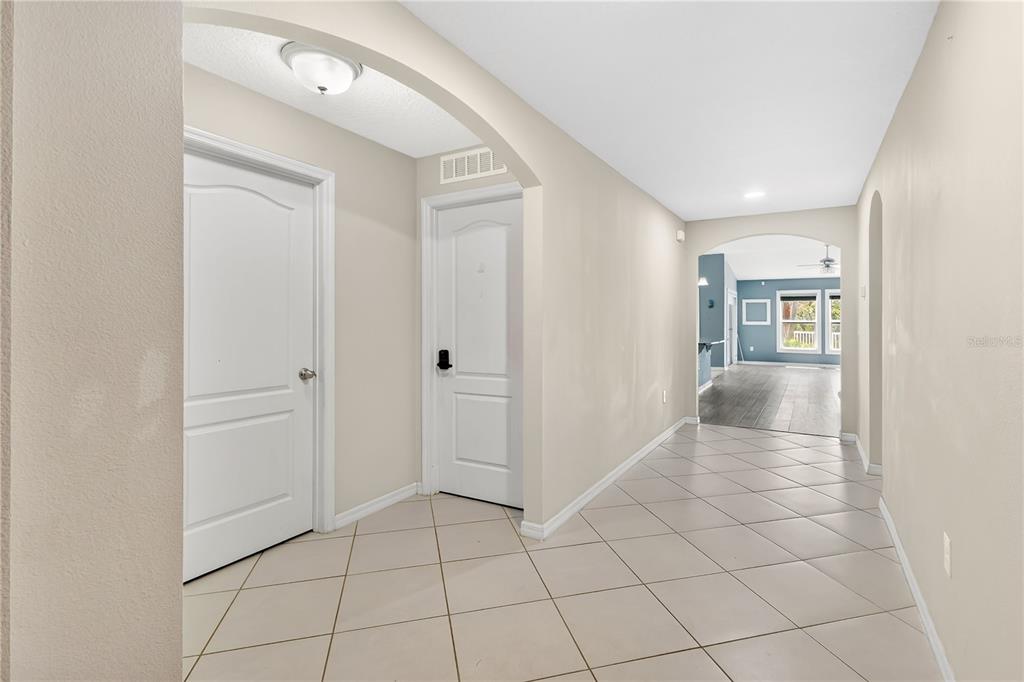 A tiled entryway leads to a hallway with two white doors and an arched opening — 116 WHIRLAWAY DRIVE, DAVENPORT, FL