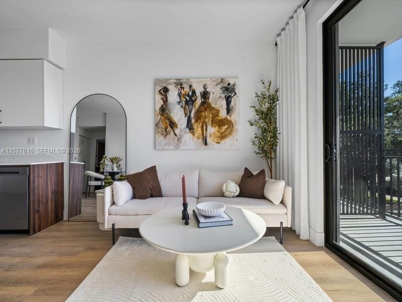 A living room features a beige sofa, a round coffee table, and a large arched mirror — 2479 NE 192nd St # 207, Miami FL 33180, MIAMI, FL