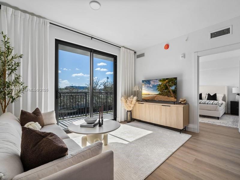 A living room features a sofa, a television on a console, and a balcony view — 2479 NE 192nd St # 207, Miami FL 33180, MIAMI, FL