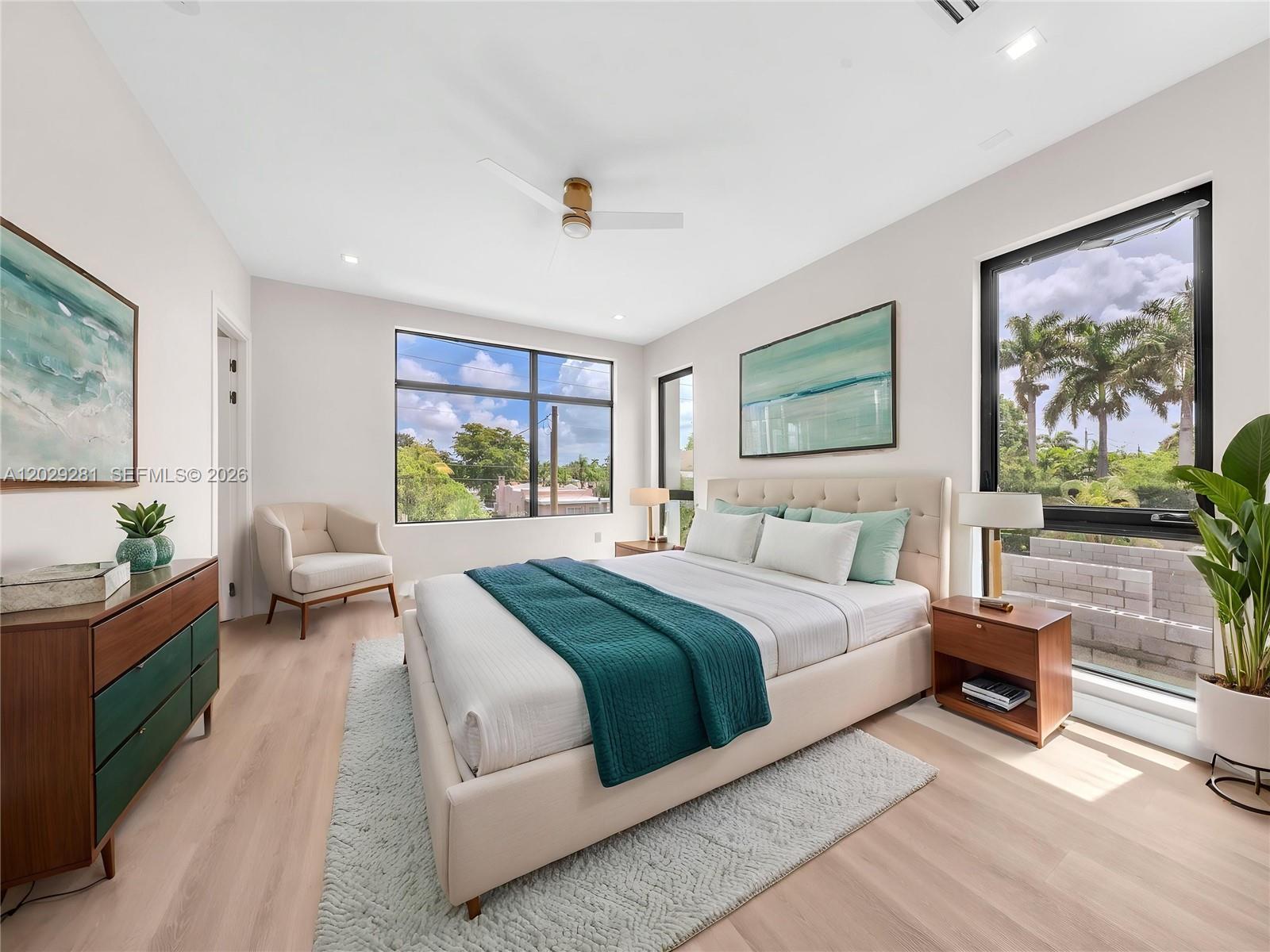 A modern bedroom features a platform bed, large windows, light wood flooring, and green accents — 1637 Monroe St, Hollywood FL 33020, HOLLYWOOD, FL