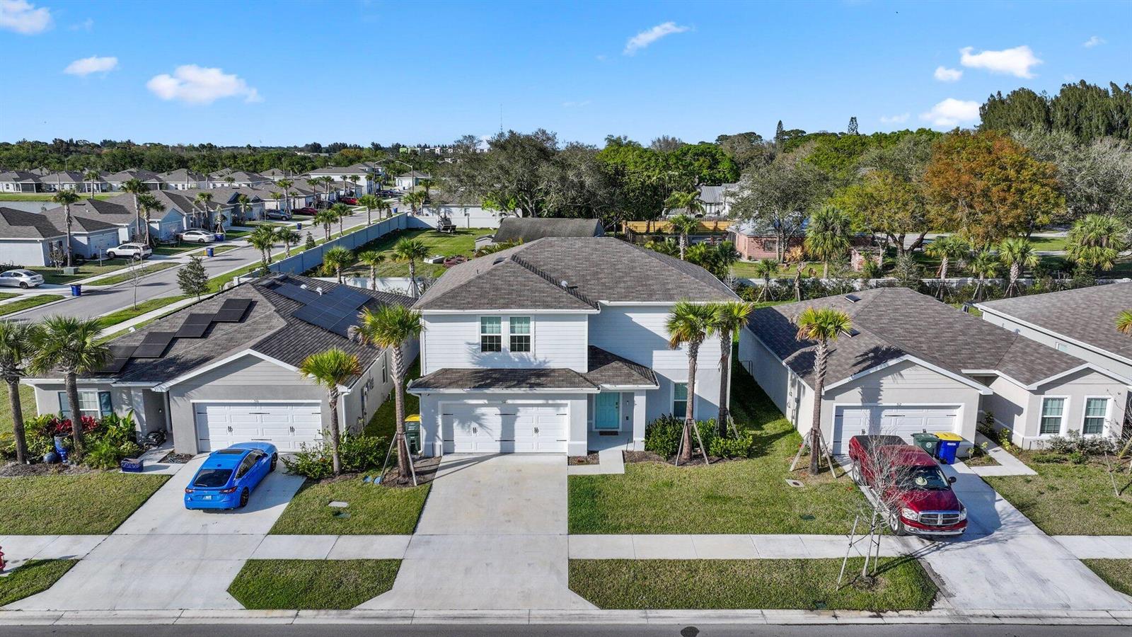 An aerial view shows a two-story house flanked by two single-story homes with driveways — 514 Raspberry Road, Fort Pierce FL 34981, FORT PIERCE, FL