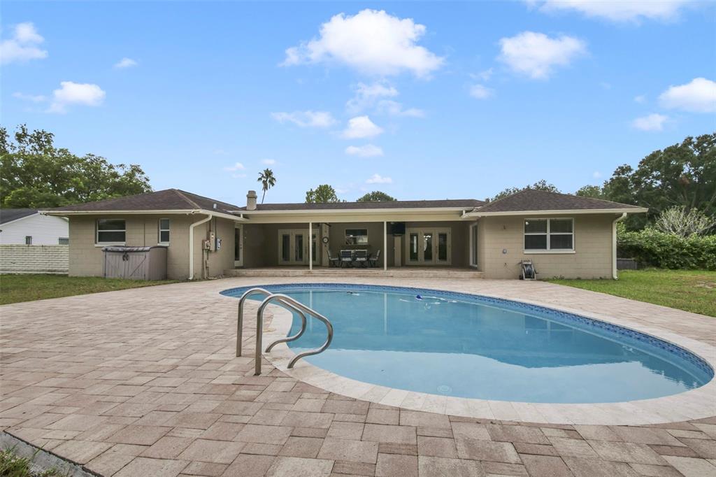 A single-story house with a backyard pool and a paved patio area — 110 LONGHORN ROAD, WINTER PARK, FL