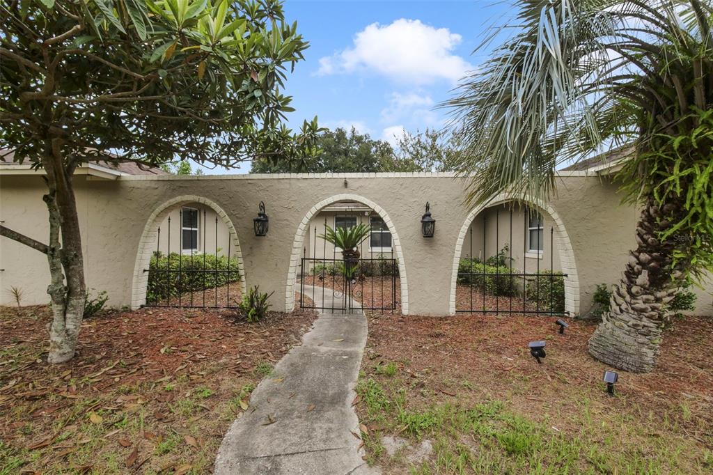 An open dining area with tile floors, a chandelier, and arched entryways to other rooms — 110 LONGHORN ROAD, WINTER PARK, FL