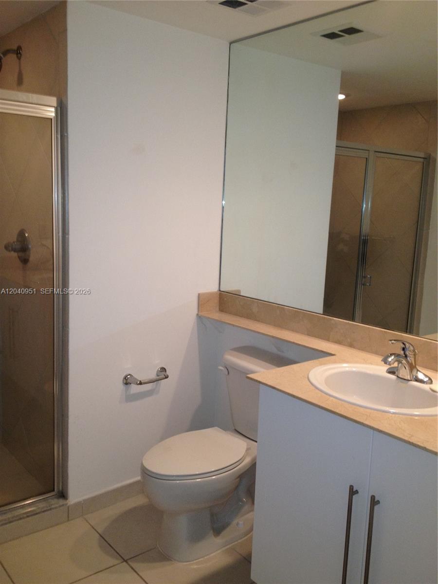 A bathroom features a toilet, a vanity with a sink, and a glass-enclosed shower — 325 S Biscayne Blvd # 1414, Miami FL 33131, MIAMI, FL