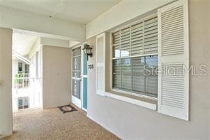 An exterior view of a covered entryway featuring a window with shutters and a door — 708 ESTUARY DRIVE UNIT 708, BRADENTON, FL