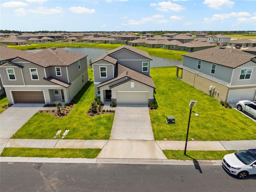 An aerial view shows a two-story suburban house with a driveway and a grassy yard — 13029 EMPRESS JEWEL TRAIL, PARRISH, FL