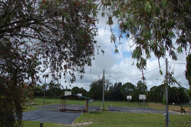 An outdoor basketball court with a covered seating area sits in a grassy park setting — 560 S Palm Street, Clewiston FL 33440, CLEWISTON, FL