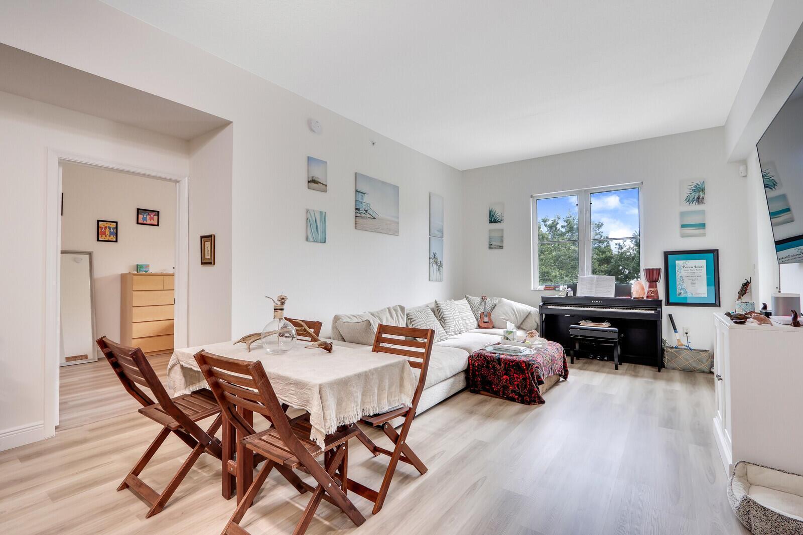 A living room features a dining set, a large sectional sofa, and an upright piano — 1155 Main Street # 216, Jupiter FL 33458, JUPITER, FL
