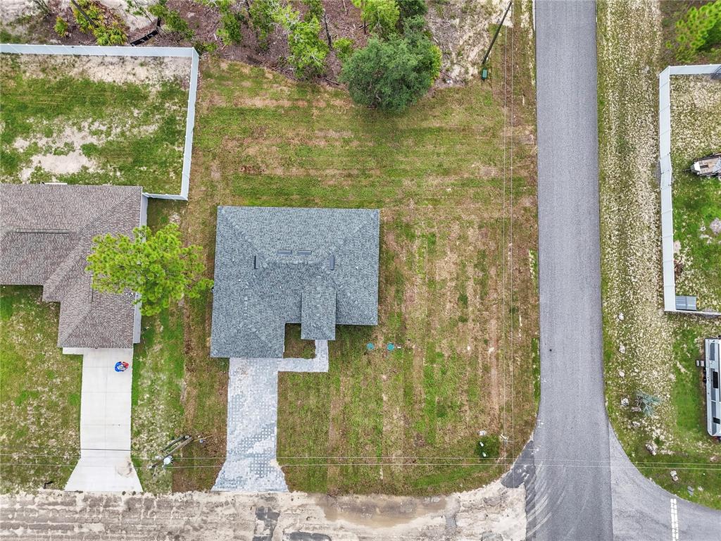 An aerial view shows a house with a gray roof, a paved driveway, and surrounding lawn — 6665 N DARLINGTON DRIVE, CITRUS SPRINGS, FL