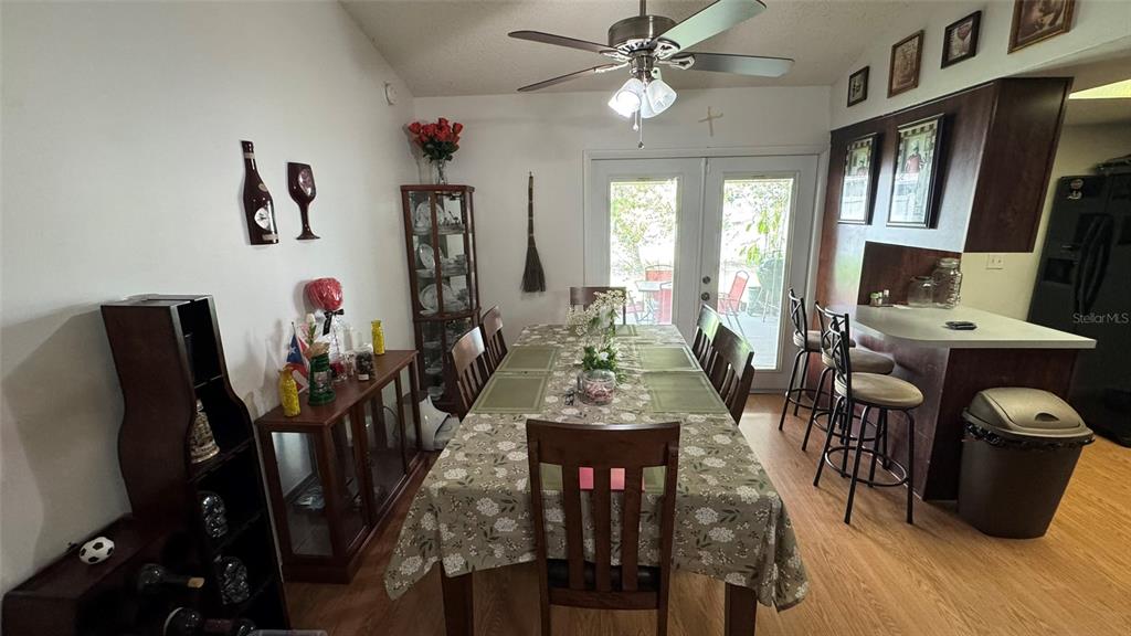 A dining room features a long table, a china cabinet, and a kitchen breakfast bar — 4026 KILLIAN DR., ORLANDO, FL