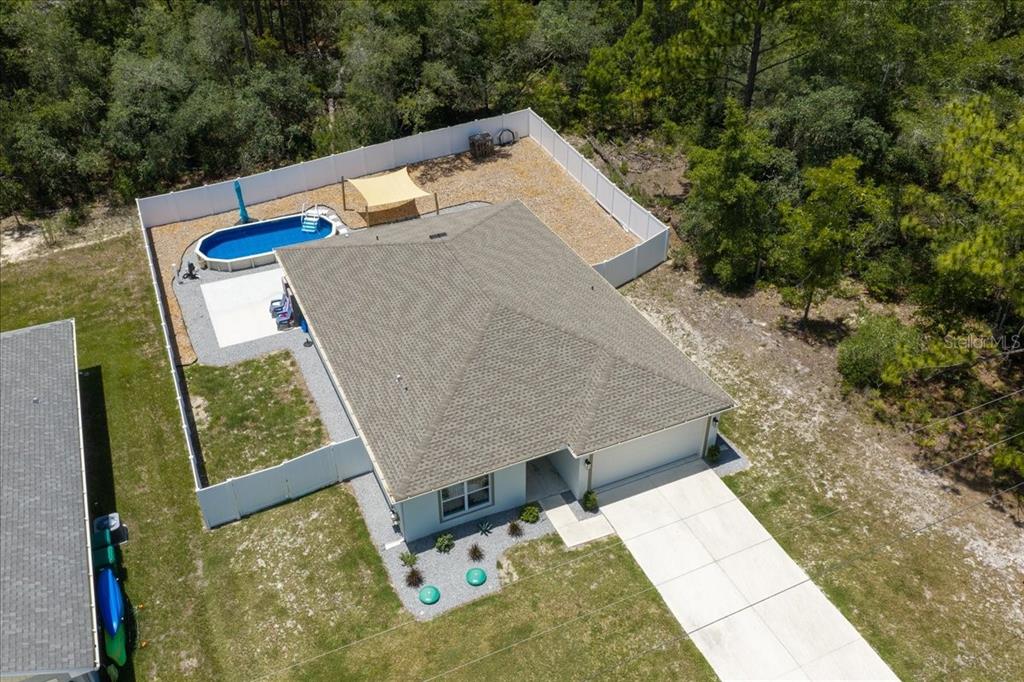 An aerial view shows a single-story house with a fenced backyard, pool, and concrete driveway — 3276 W CAMILO DRIVE, DUNNELLON, FL