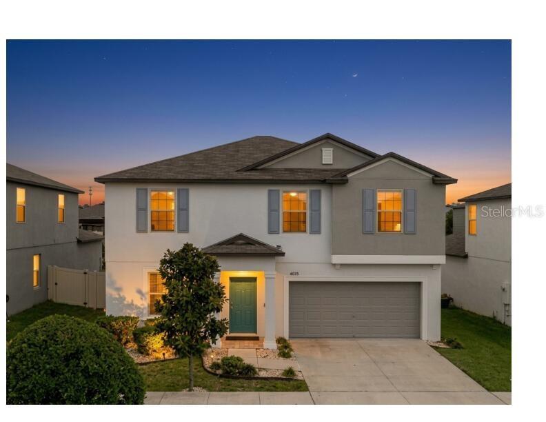 A two-story suburban house with a teal front door, gray garage, and light-colored stucco exterior — 4203 HANOVER DRIVE, NEW PORT RICHEY, FL