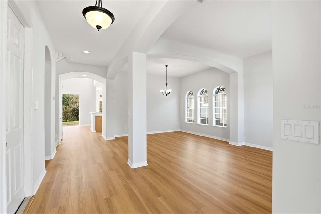 An interior view shows a hallway leading to a dining area with arched windows — 16368 TUDOR GROVE DRIVE, ORLANDO, FL