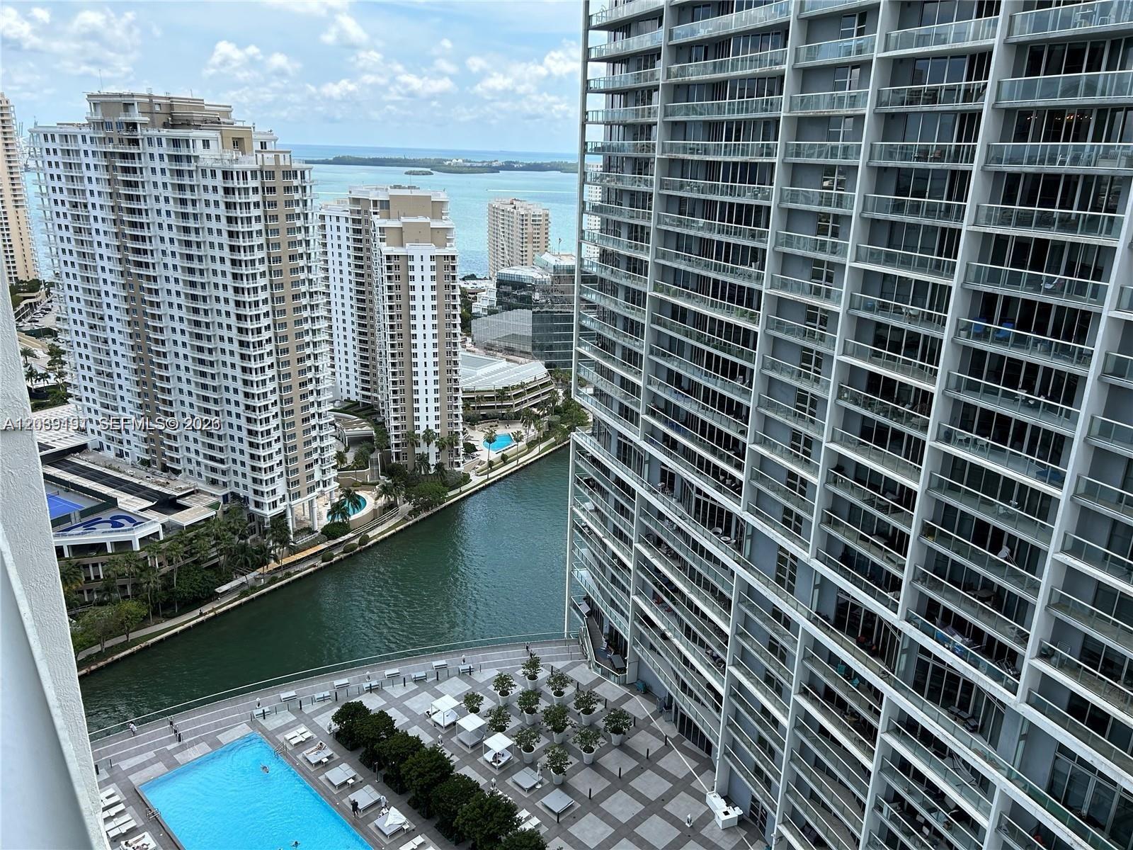 An elevated view shows a swimming pool, a canal, and several high-rise apartment buildings — 475 Brickell Ave # 3113, Miami FL 33131, MIAMI, FL