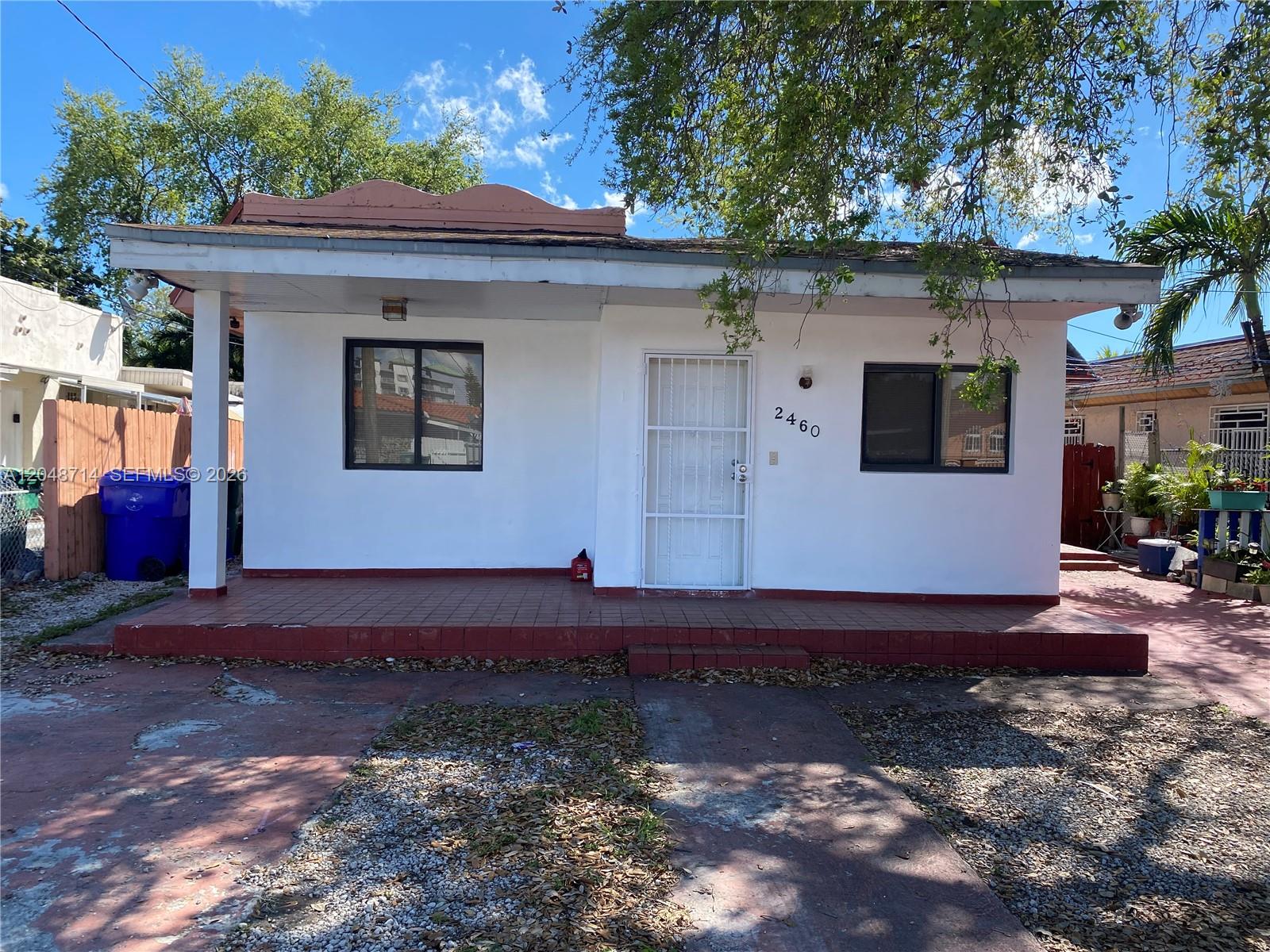 A single-story white house with a red tiled front porch and a security screen door — 2460 NW 15th St # 4, Miami FL 33125, MIAMI, FL