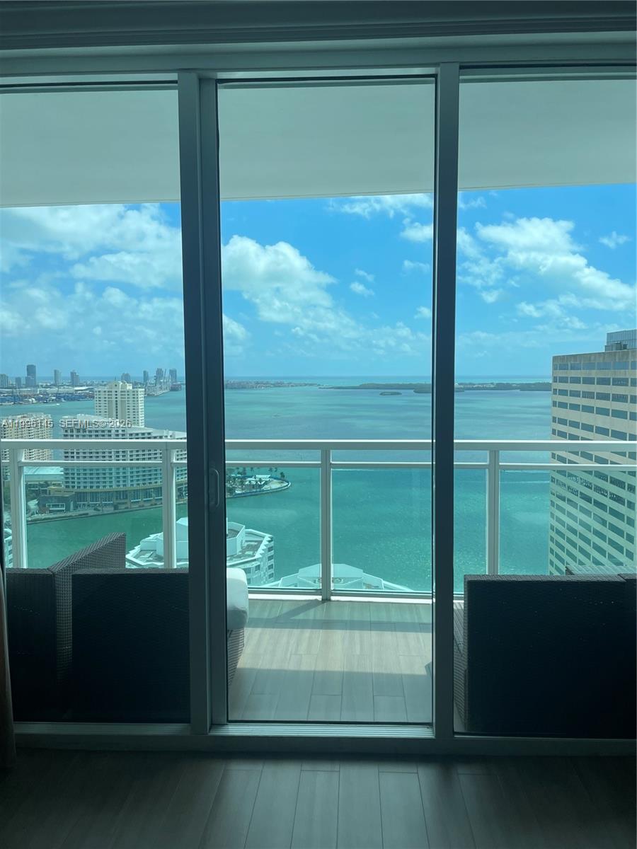 A view of the ocean and city skyline from a balcony through sliding glass doors — 951 Brickell Ave # 3506, Miami FL 33131, MIAMI, FL