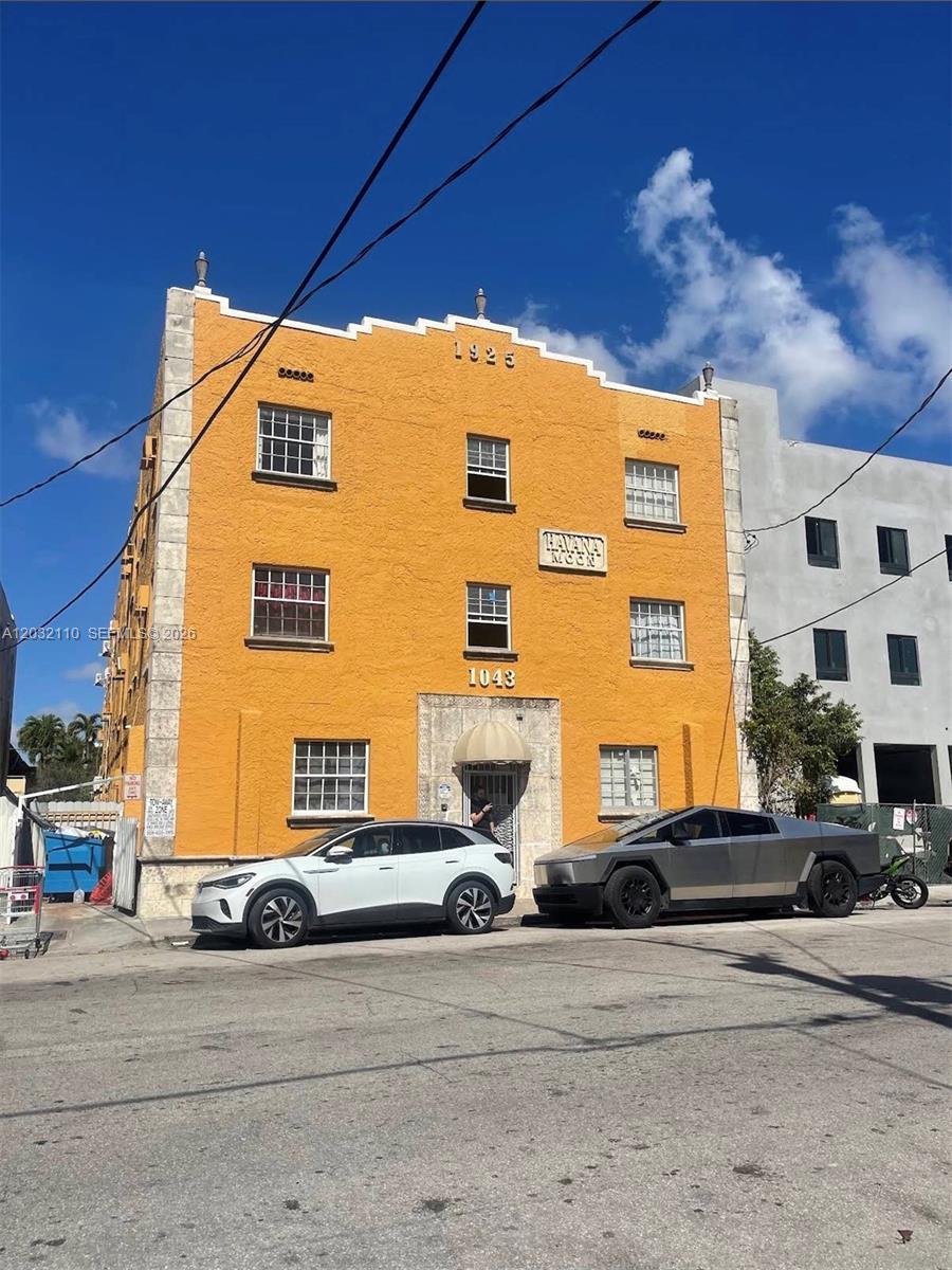 A yellow three-story building with a white car and a silver truck parked in front — 1043 NW 2nd St # 2, Miami FL 33128, MIAMI, FL