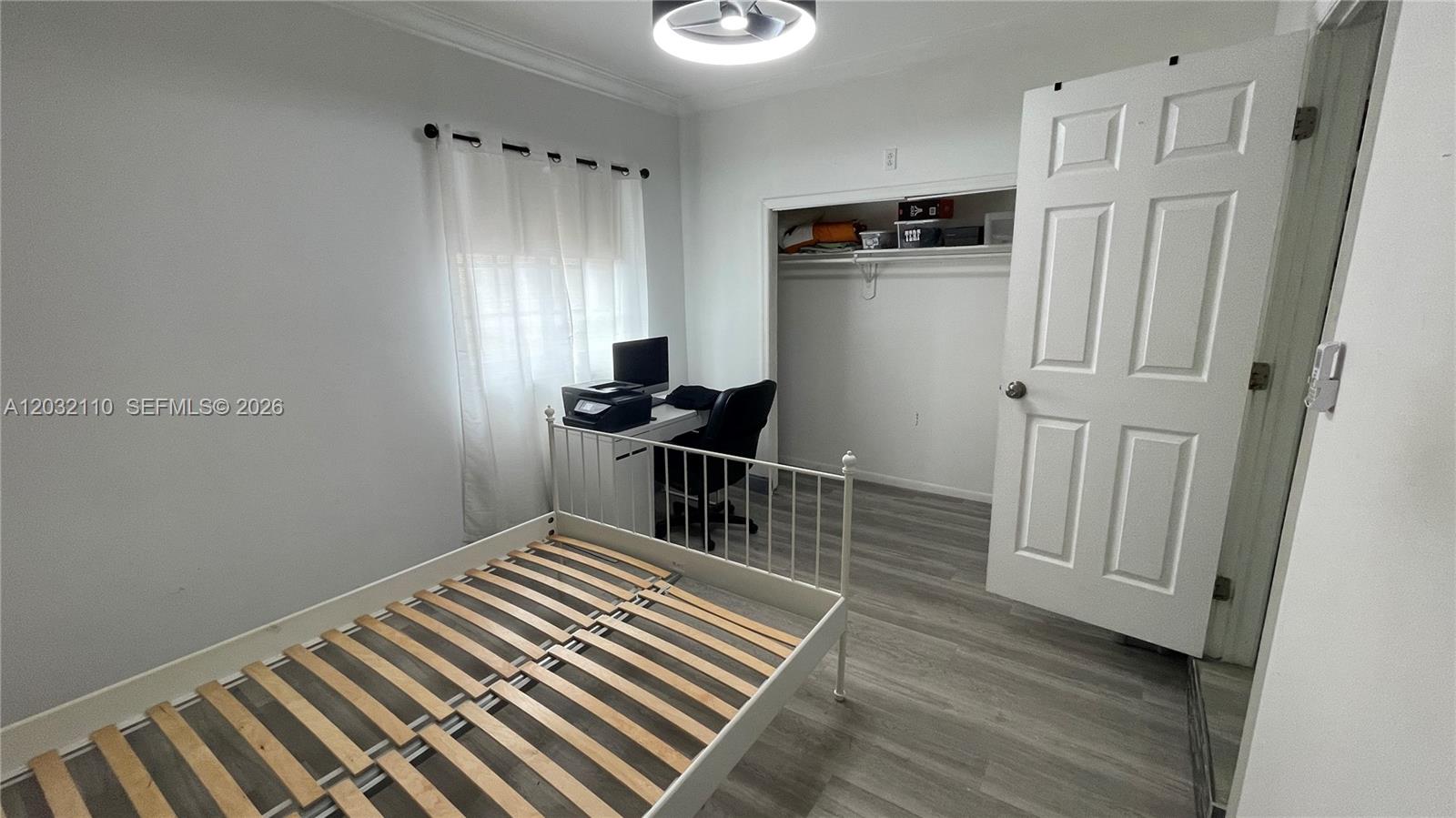 A bedroom features a white metal bed frame, a desk with a computer, and a closet — 1043 NW 2nd St # 2, Miami FL 33128, MIAMI, FL