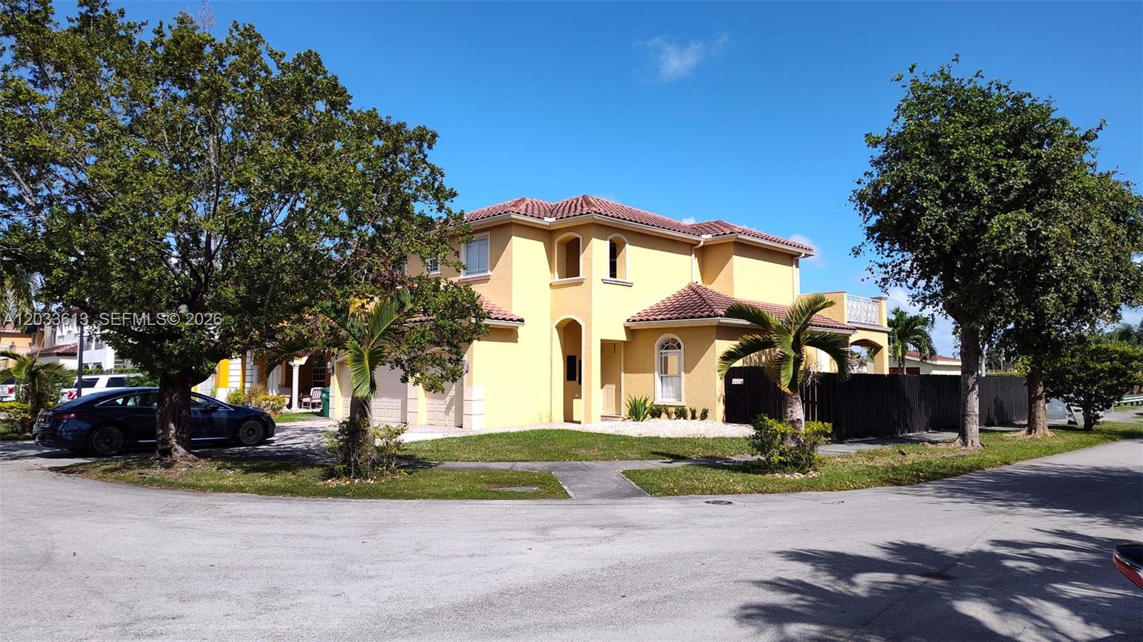 A two-story yellow stucco house with a tiled roof sits on a corner lot — 6743 SW 163rd Pl, Miami FL 33193, MIAMI, FL