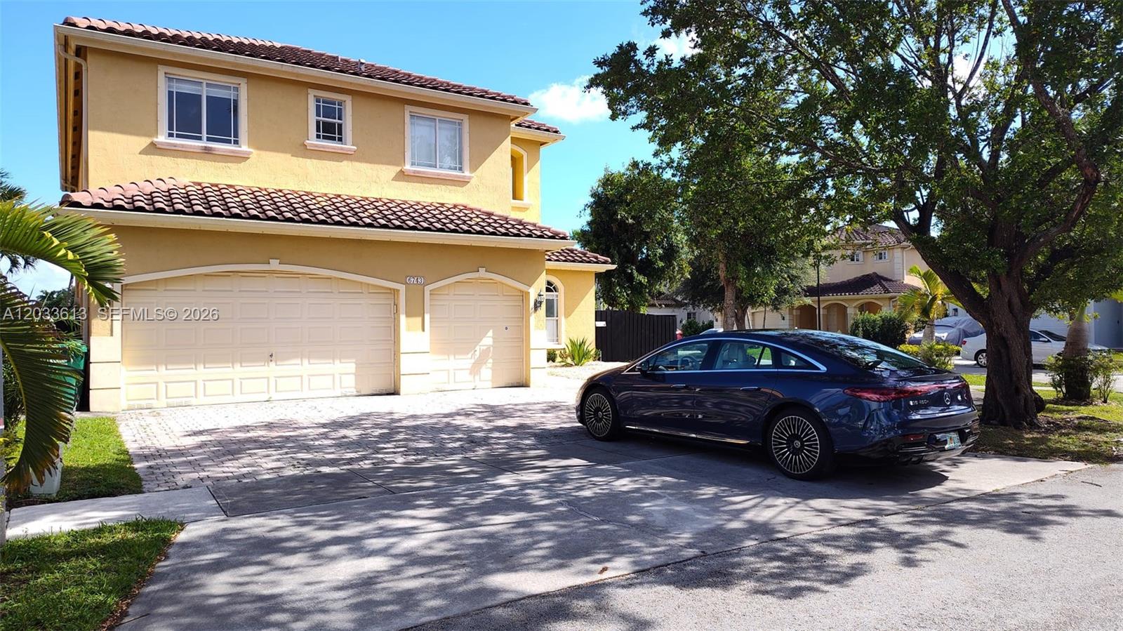 A two-story yellow stucco house with a tile roof and a dark sedan parked outside — 6743 SW 163rd Pl, Miami FL 33193, MIAMI, FL